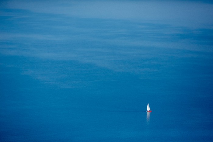 Rotes Schiff Mit Weissen Segeln auf Blauem Wasser
